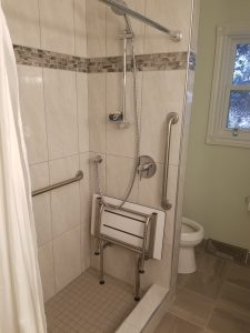 stainless steel grab bars and a phenolic resin fold-up shower seat
