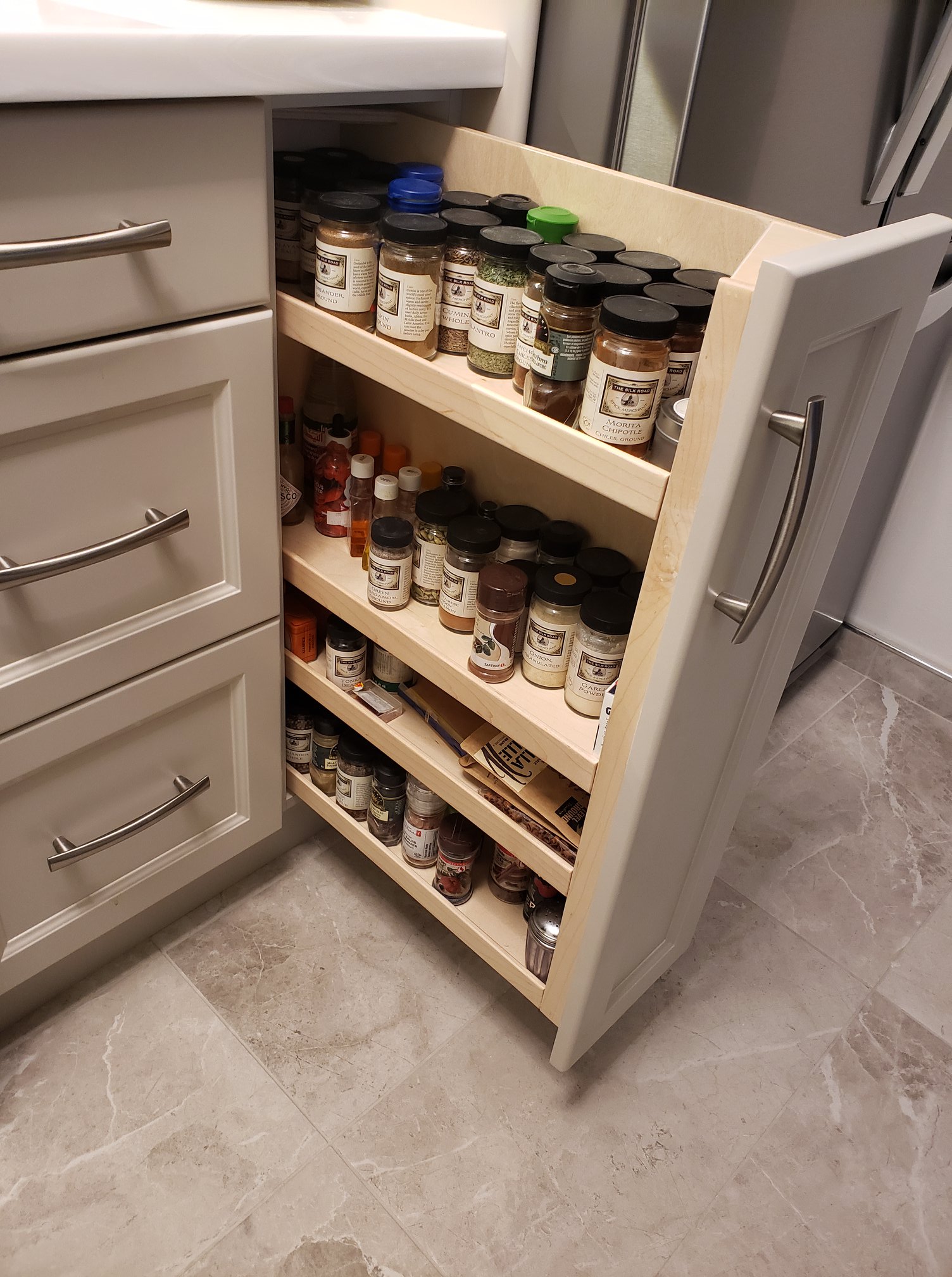 Here is the pull out spice rack all loaded up with my client's spices for cooking.
