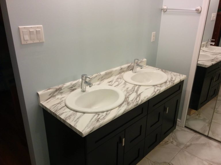 Stained maple vanity, laminate counter top, and higher end sink bowls and taps. The client also chose luxury vinyl tile to complement the rest of the bathroom